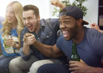 grupo de amigos torcida assistindo televisão celebrando festa amizade felizes sofá casa