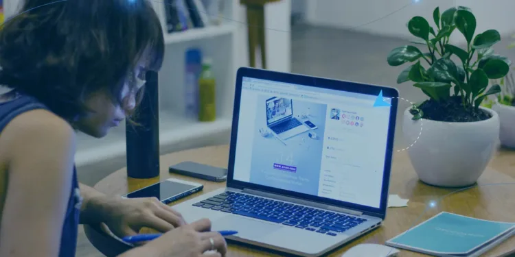 Mulher de cabelos curtos segurando lápis mão direta na frente um notebook ligado objetos sobre a mesa